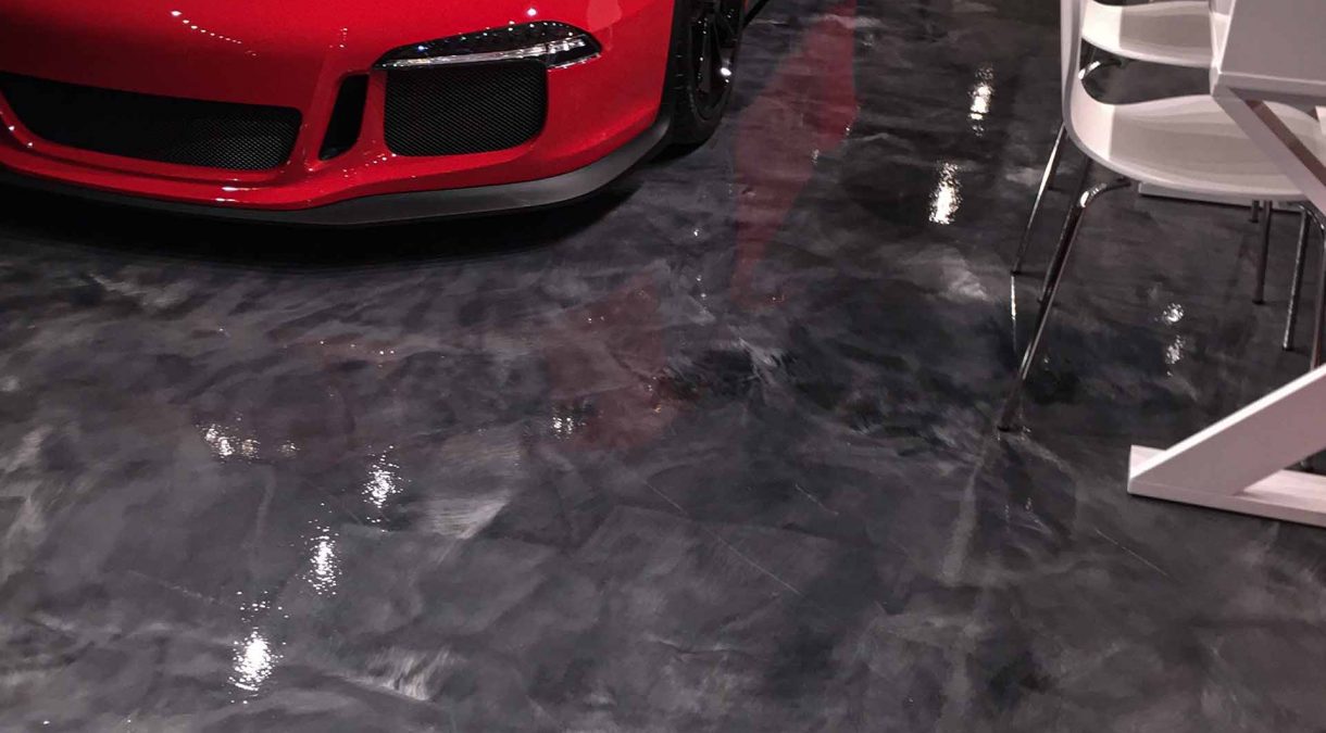 Red performance car parked on a Titanium metallic epoxy floor